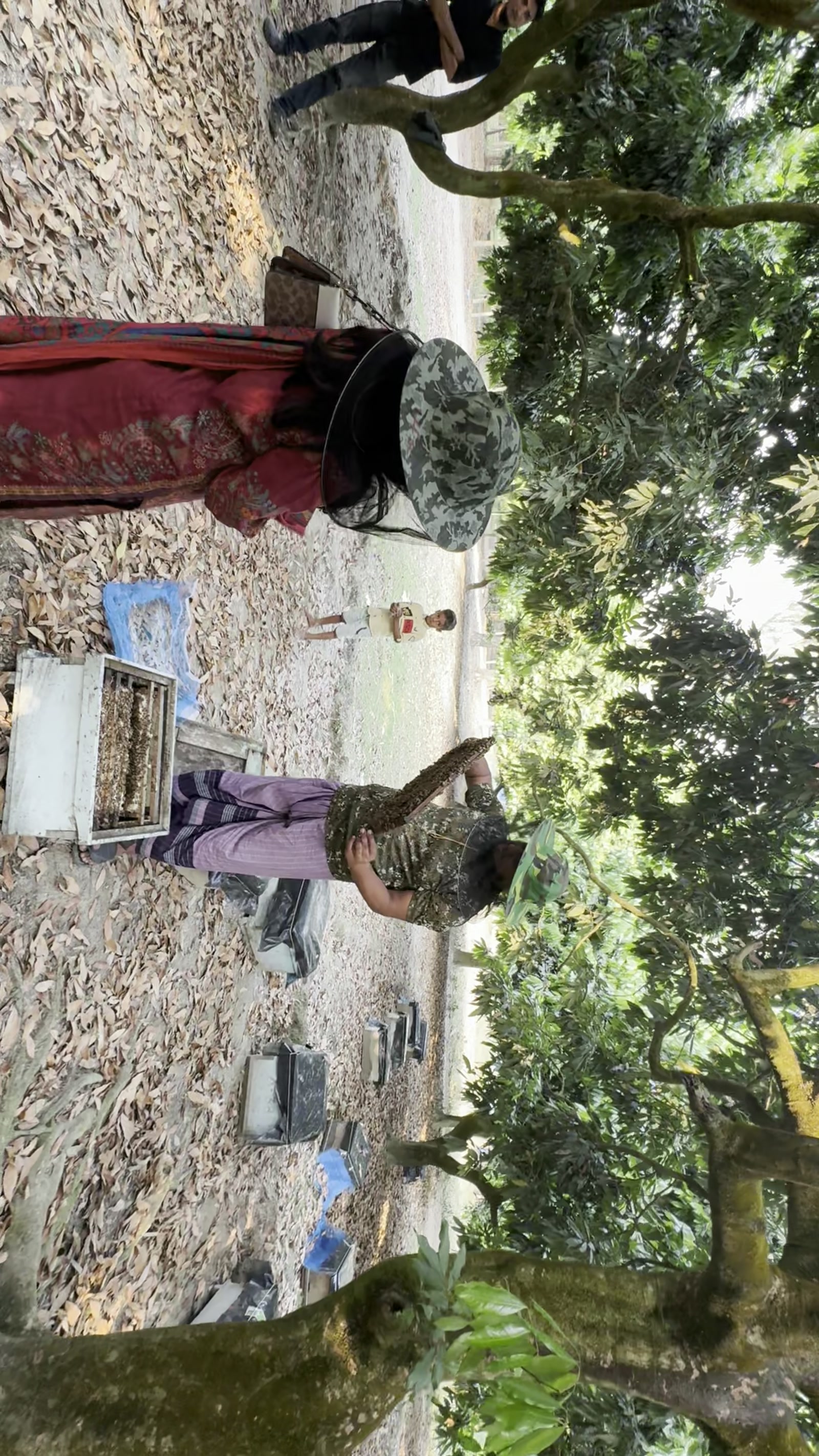 Shifa and beekeepers inspecting beehive