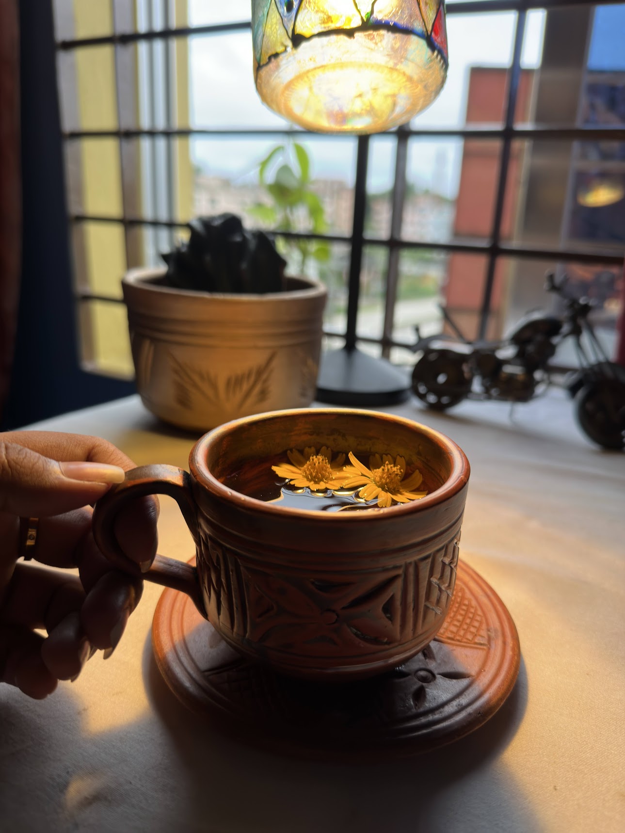 Hand holding terracotta cup with tea