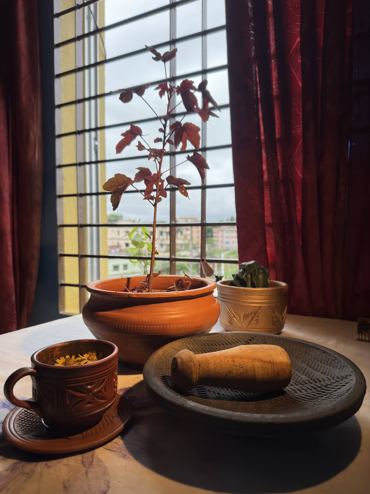 Terracotta pottery collection on windowsill