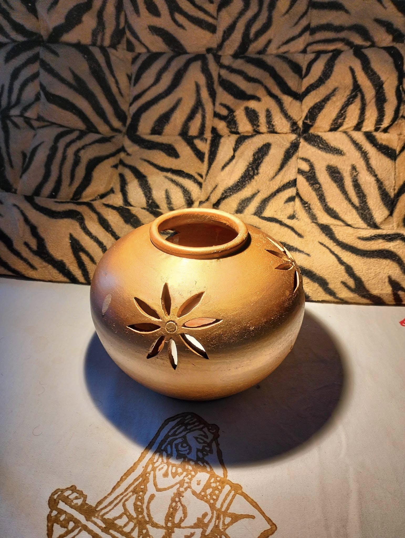 Terracotta candle lamp with carved floral cutouts